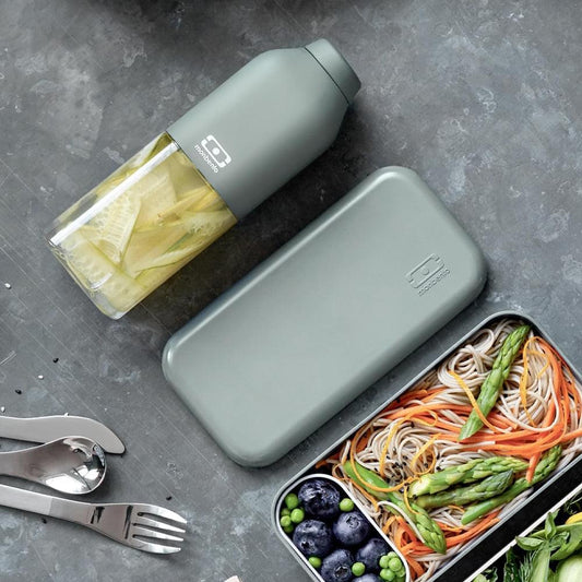 Green reusable water bottle lying down with cap on and label visible