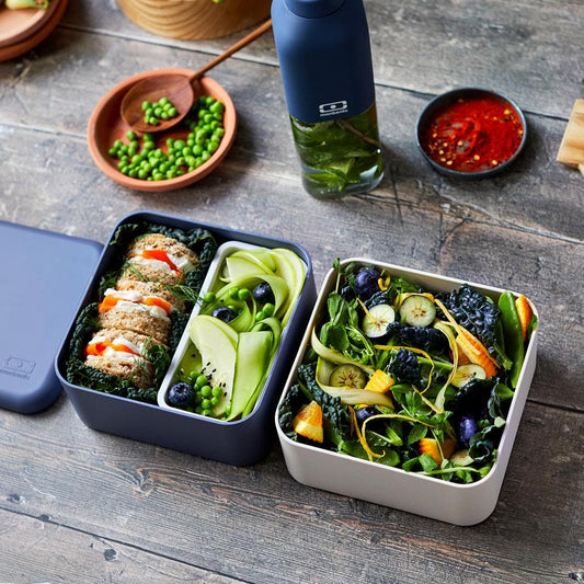 Square bento box with vegetable and rice compartments in a dark blue tray