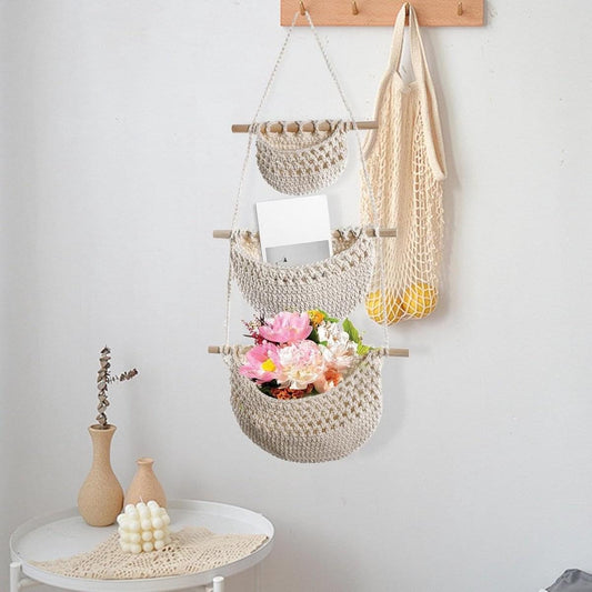 Woven linen hanging organizer with three fabric baskets, wooden bars, and rope ties