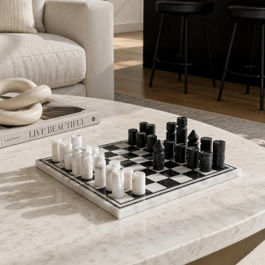 Inlaid marble chess set on a tabletop, showing white and dark chess pieces.