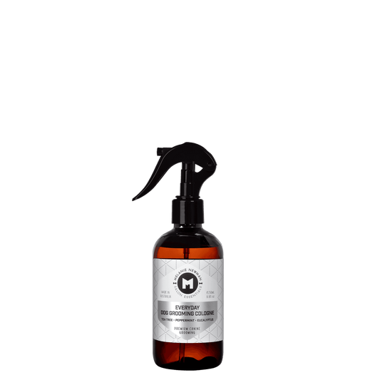 Everyday dog grooming cologne spray bottle with black trigger and orange liquid