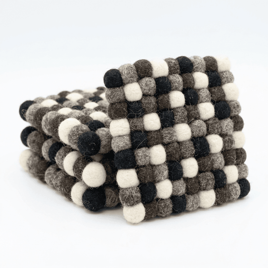 Round wool felt coaster with raised pebble texture and dark cream gray stripe pattern