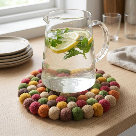 Round wool felt heat mat with multicolor felt ball ring under a glass jug