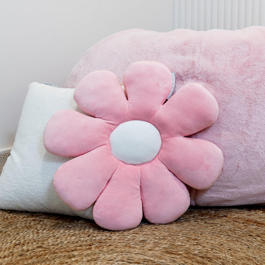 Pink daisy-shaped plush pillow with rounded petals and a white fabric center