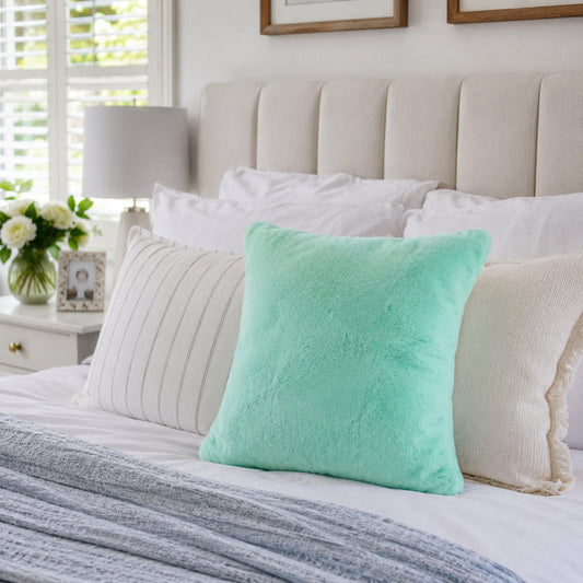 Turquoise plush fur cushion cover with insert, square pillow with soft cloud-like texture.