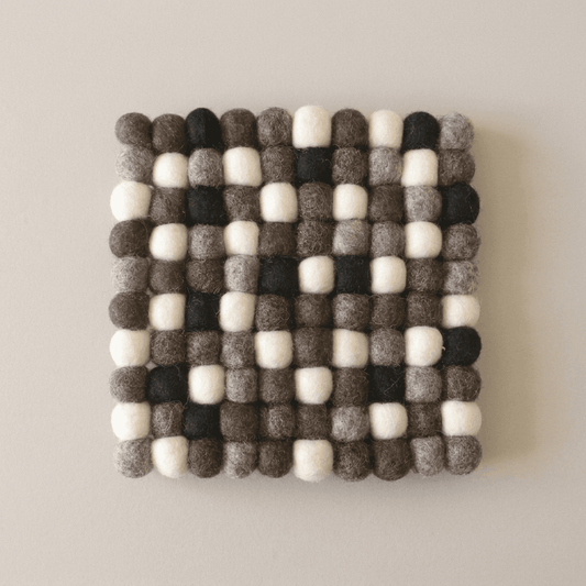 Square wool felt trivet with pebble spheres, charcoal and cream checker-like pattern