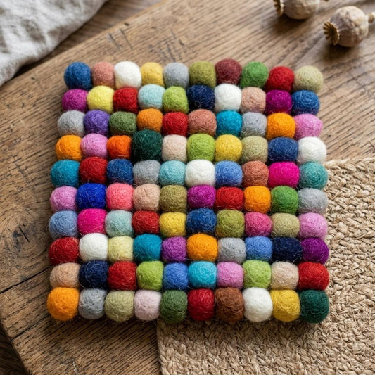 Handmade wool felt trivet with colorful felt pom-pom confetti border