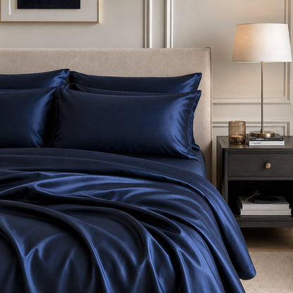 Navy blue satin sheet set with pillow shams and smooth fitted sheet, neatly draped