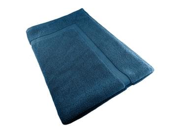 Teal cotton bath mat, folded, textured surface and stitched edges