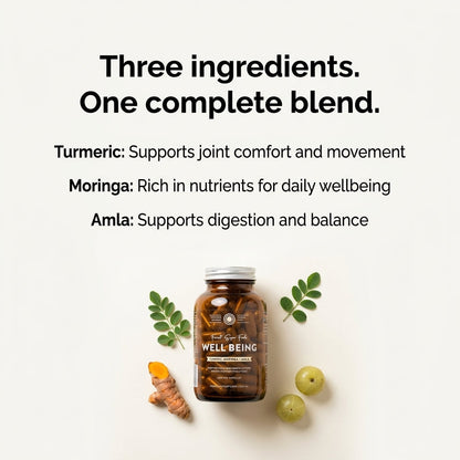Turmeric+ Whole Food Blend bottle with moringa leaves and amla fruit on a flat surface