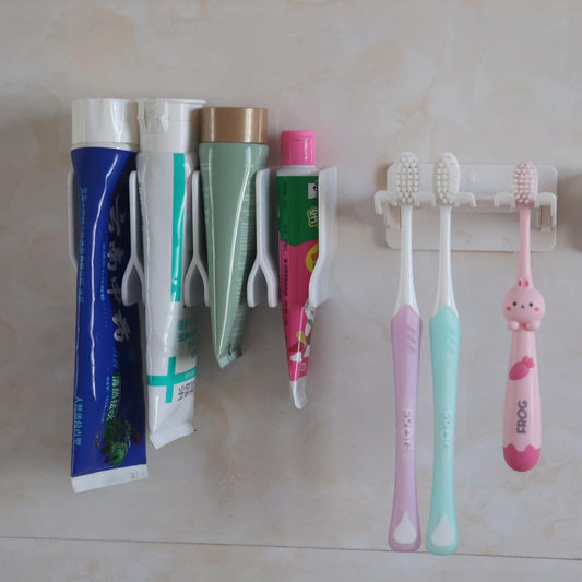 White wall-mounted drying rack with multiple hanging clips, holding bathroom items on pegs.