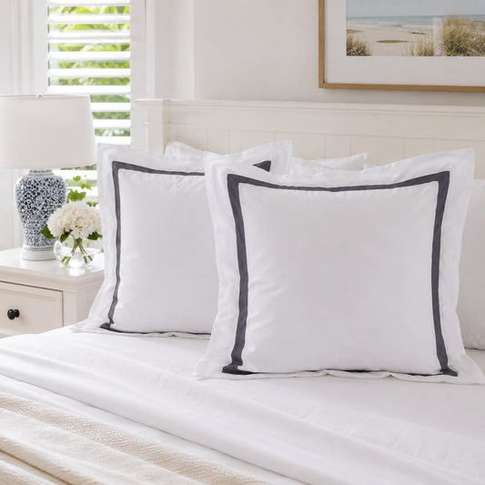 White European pillowcases with charcoal trim, two pillows on bed