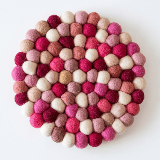 Round wool felt trivet with berry, pink, and cream pom-pom pattern