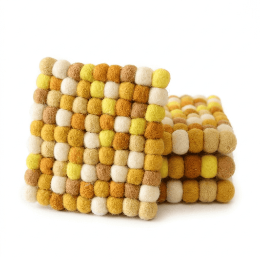 Square wool felt coaster with clustered ball texture in mustard, white, and light green.